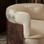 Oko tugitooli detailivaade, pehme tekstuuriga polster ja skulpturaalne puidust seljakest.